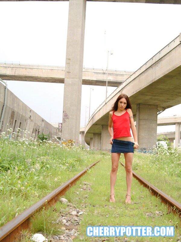 Free porn pics of Cherry Petite getting naked on an abandoned rail road 1 of 125 pics