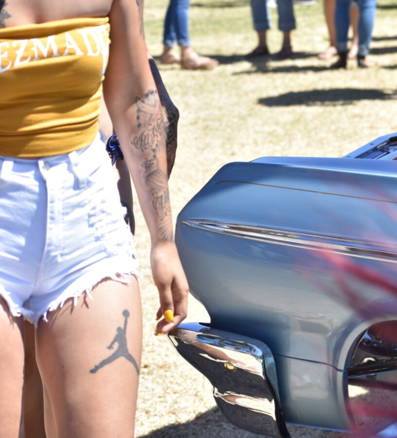 Free porn pics of Car show Latina in white booty shorts and a yellow top 15 of 17 pics