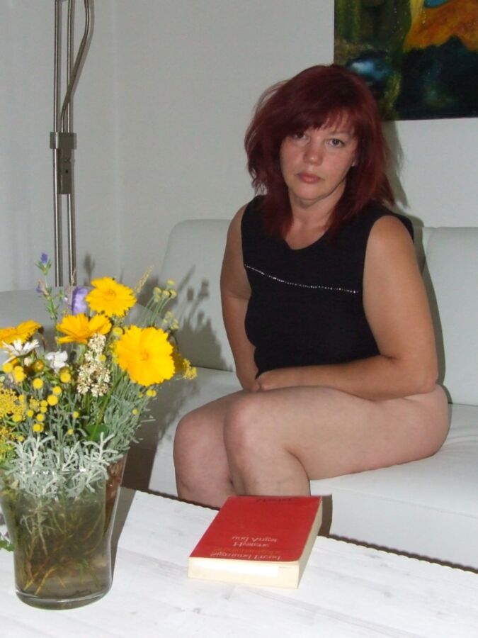 Mature redhead Julia poses on her white couch. 2 of 91 pics